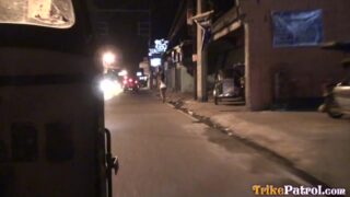 Nighttime Scene of a Woman Walking Down a Street in a City with a Trike Patrol Logo in the Corner